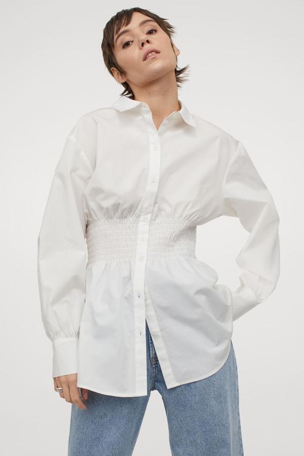 Blusa de algodón con cintura amplia fruncida con cuello camisero, cierre de botones, mangas globo amplias y maxipuños ceñidos con dos botones, de H&M (19,95 €).