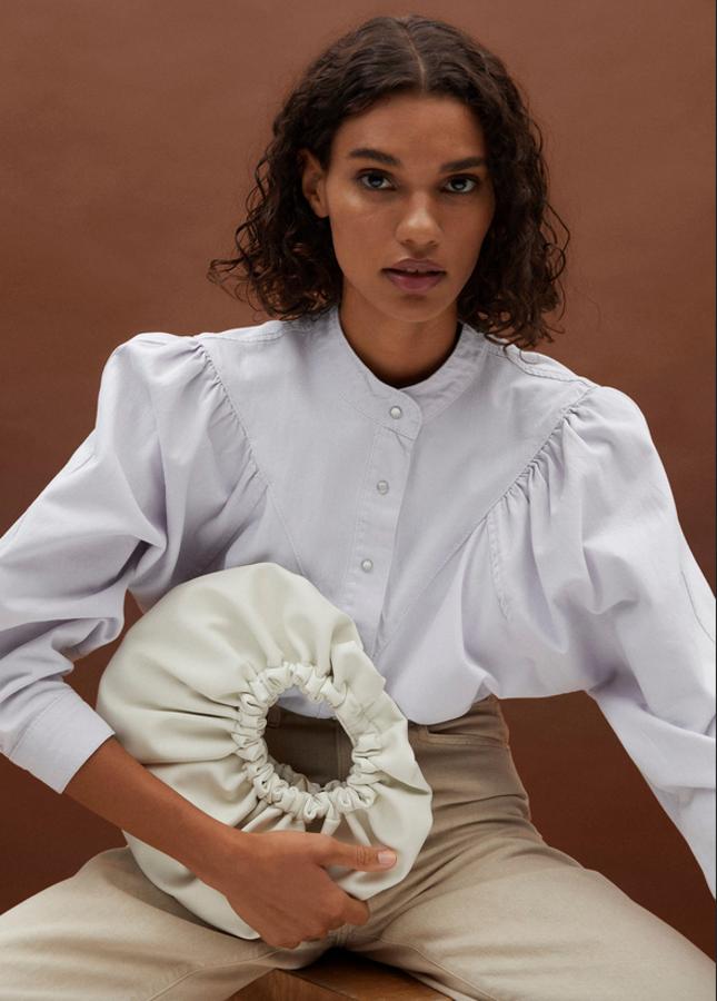 De venta exclusiva en la web de la firma y disponible en blanco o en color lila, este bolso de diseño redondo con cierre de imán interior y detalles fruncidos tiene un precio de 29,99 euros.