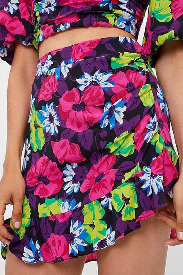 Esta falda corta, con volante en el bajo y diseño tipo pareo conseguirá que tus piernas parezcan larguísimas.