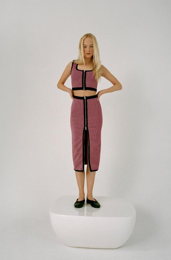 Top corto de escote redondo, tirantes anchos y estampado jacquard. Cremallera frontal que sirve tanto para cerrar la prenda como detalle decorativo. Puede llevarse con la falda a conjunto, con el mismo estampado y detallede cremallera. Su precio es de 15,95 euros y el de la falda 19,95 euros.