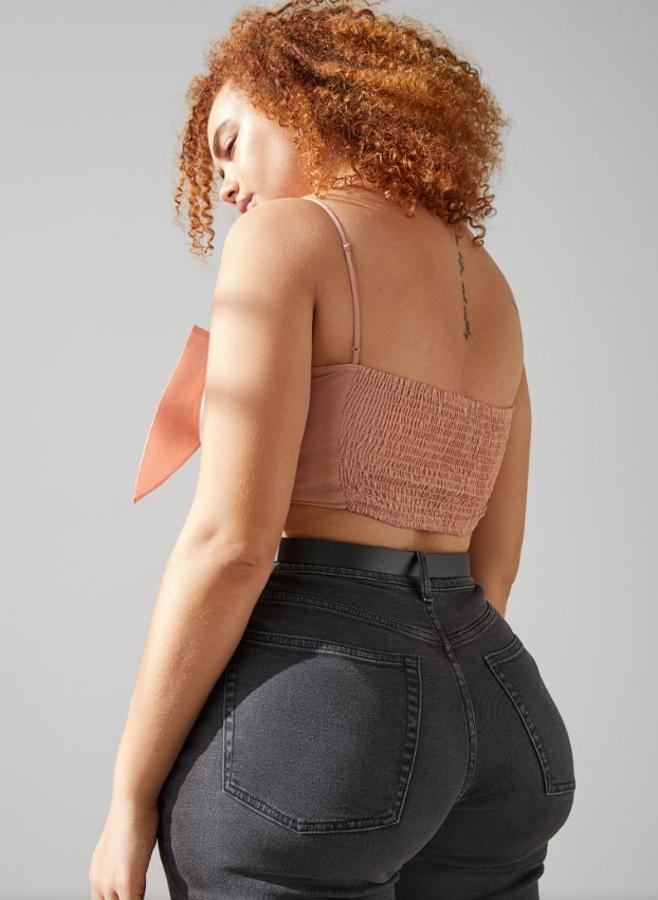 Top corto de tafetán con maxilazo delante, tirantes finos ajustables y fruncido de nido de abeja en la espalda. Disponible en dos colores, rosa empolvado y negro. Precio actual: 9,99 euros.