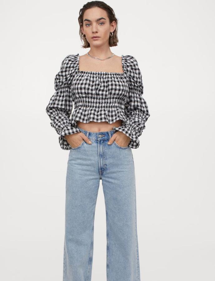 Top cropped con escote cuadrado, elástico oculto y ribete de volante, bajo fruncido y peplo con vuelo. Mangas largas abullonadas con costuras fruncidas para un toque extra de volumen y volante acampanado en los puños. Disponible en tres estampados: de cuadros negros y blancos, negro con print floral y blanco. Precio actual: 17,99 euros.