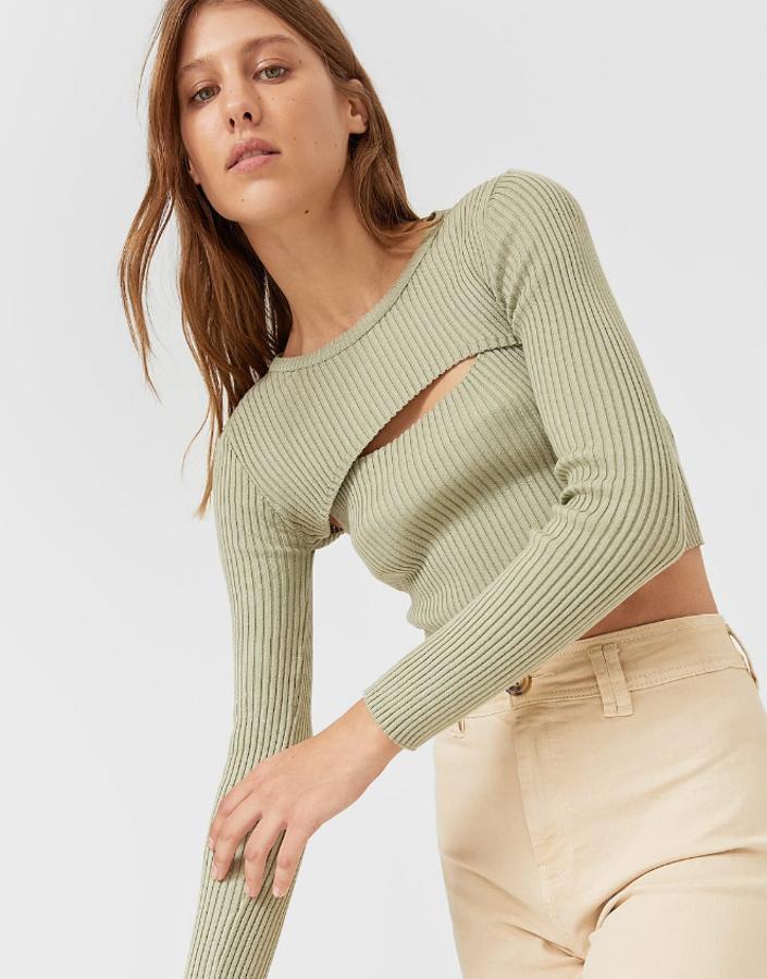 Jersey corto de cuello redondo y manga larga con detalle de abertura en la parte delantera y en la espalda. Está disponible en tres colores, piedra, verde y negro y su precio es de 19,99 euros.