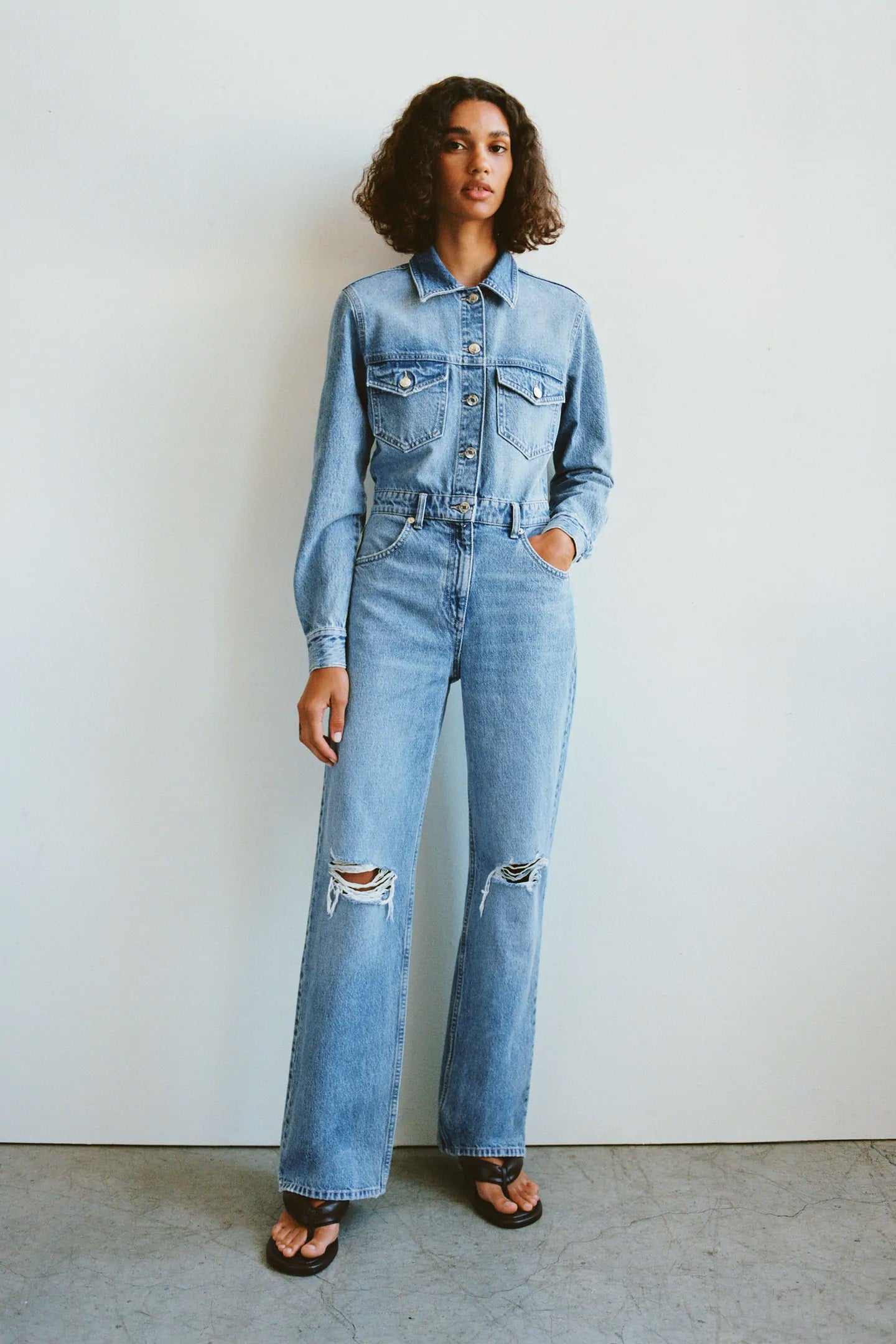 Zara también se apunta a la tendencia del mono vaquero con este diseño de algodón orgánico en color denim efecto lavado, con cuello solapa, cierre de botones, bolsillos delanteros y pantalones anchos con rotos. (39,95 euros).