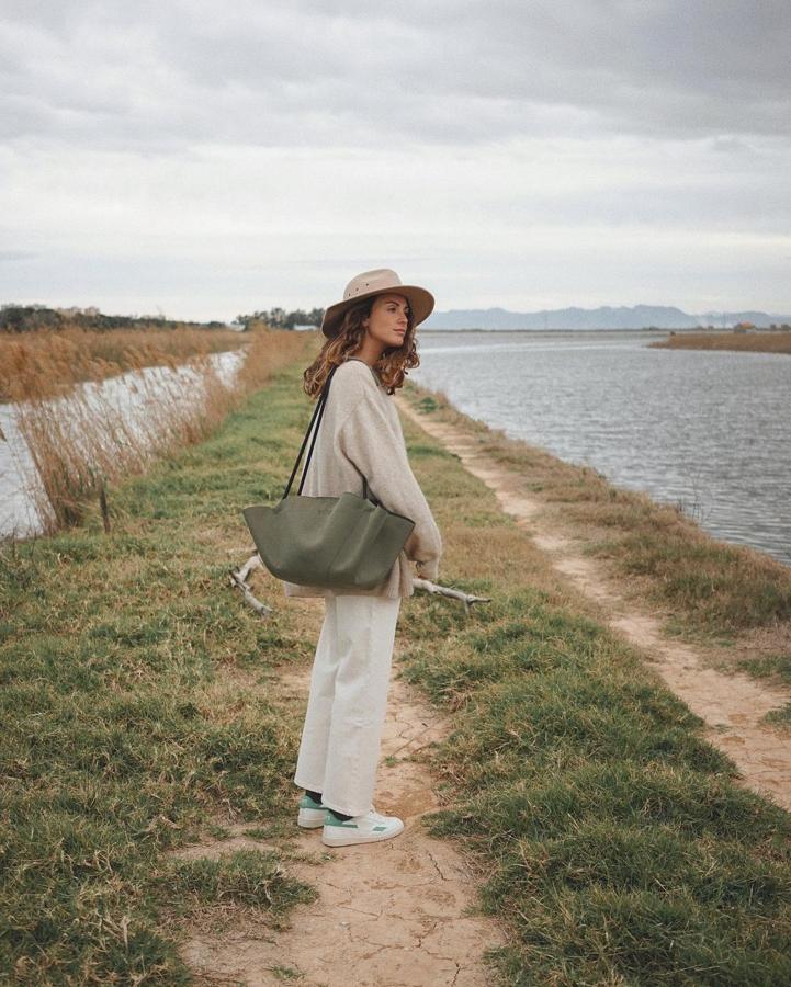 Jersey d epunto color arena + vaqueros anchos `zapatillas blancas + bolso asa larga de color caqui (@mirenalos)