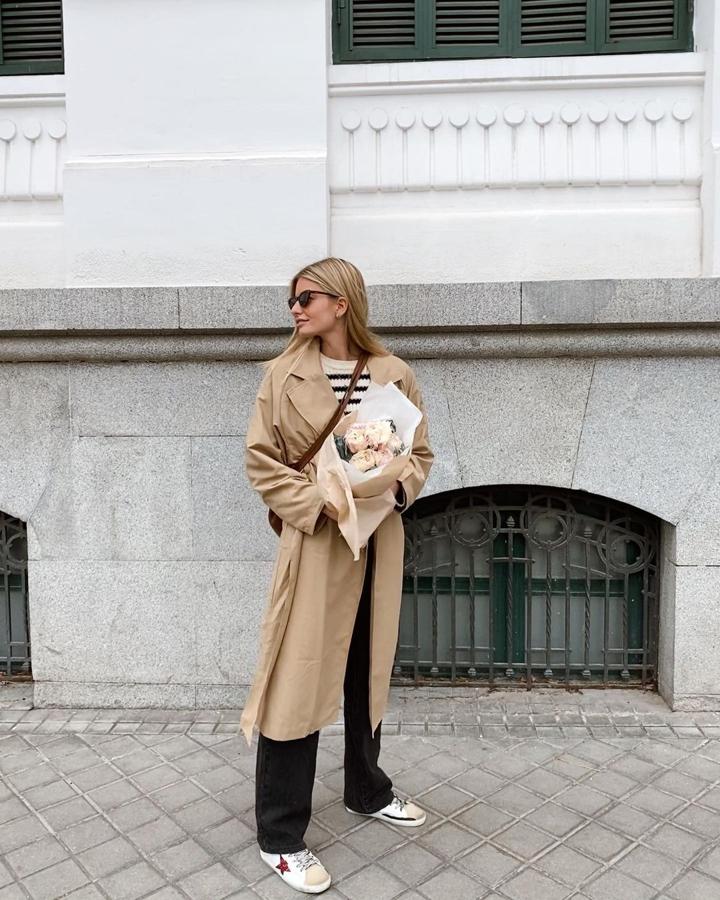 Trench en color camel + jersey de rayas + pantalón recto negro + zapatillas blancas (@mariagarridost)