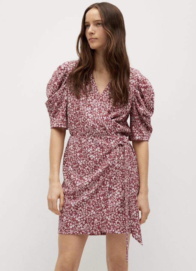 Este vestido corto con estampado floral en color granate cuenta con escote de pico cruzado y manga corta abullonada. Es de Mango y tiene un precio de 25,99 euros.
