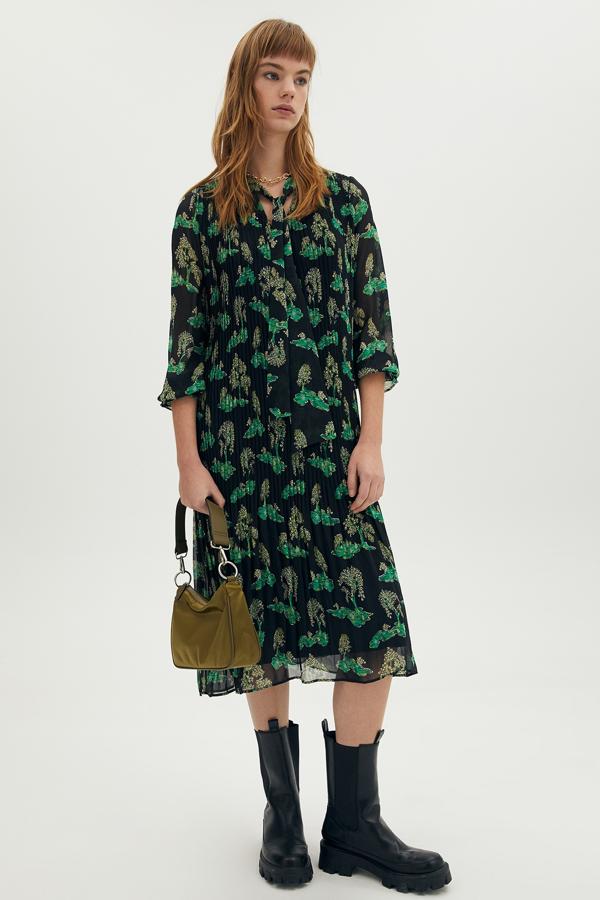 En tejido plisado de color negro con estampado en verde, este vestido largo con lazada es de Sfera y tiene un precio de 29,99 euros.