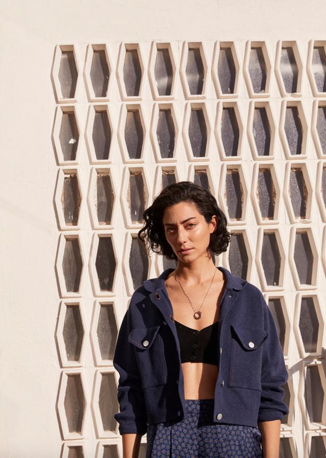 Diseño oversize cropped para este cárdigan de Mango en algodón con cuello de solapa, mangas largas con puños abotonados y costuras decorativas en contraste y color naranja. Con dos bolsillos de solapa con botón en el frontal y cierre de botones metalizados, tiene la costura de hombro caída y cuesta 49,99 euros. Podemos encontrarlo entre las tallas XS y XL.