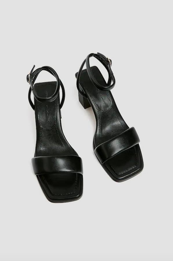 Con tacón de 8 centímetros y tira acolchada en la parte delantera, estas sandalias negras de Pull&Bear con cierre de hebilla en el tobillo cuestan 25,99 euros y están disponibles entre los números 35 y 41.