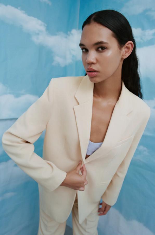 Diseño fluido para esta blazer recta en amarillo pastel de Zara con cuello y solapa con muescas, mangas largas con hombreras y bolsillos de doble vivo en los laterales y la pechera. Con bajo con abertura en la espalda y cierre frontal de botones, cuesta 49,95 euros y está disponible entre las tallas XS y XXL.