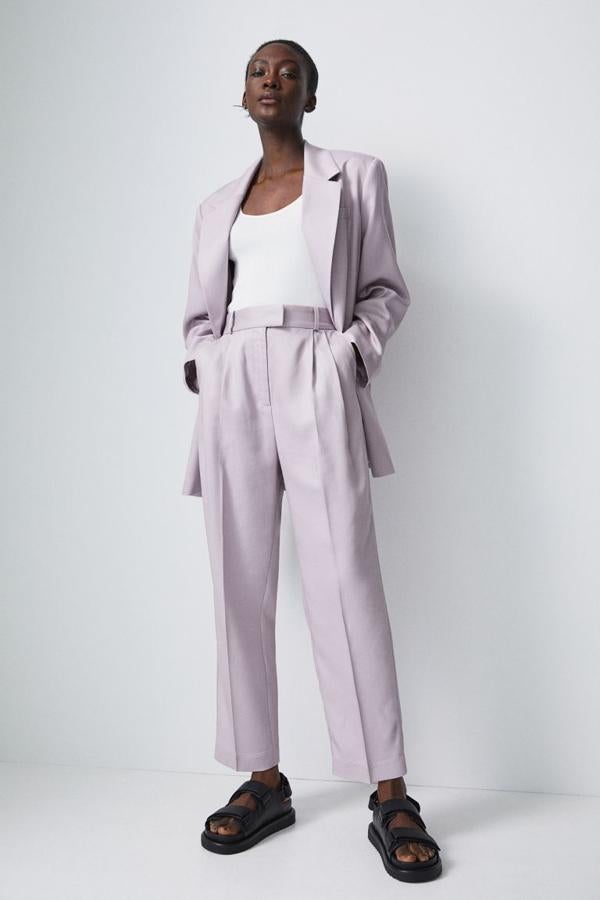 A juego con la americana y de venta exclusiva en la web, este pantalón tobillero con raya es de talle alto con elástico en la parte posterior de la pretina viene con bolsillos al bies y bolsillos decorativos detrás. Tiene pliegues delante y pinzas detrás para estilizar la figura, cuesta 24,99 euros y está disponible entre las tallas 32 y 50.