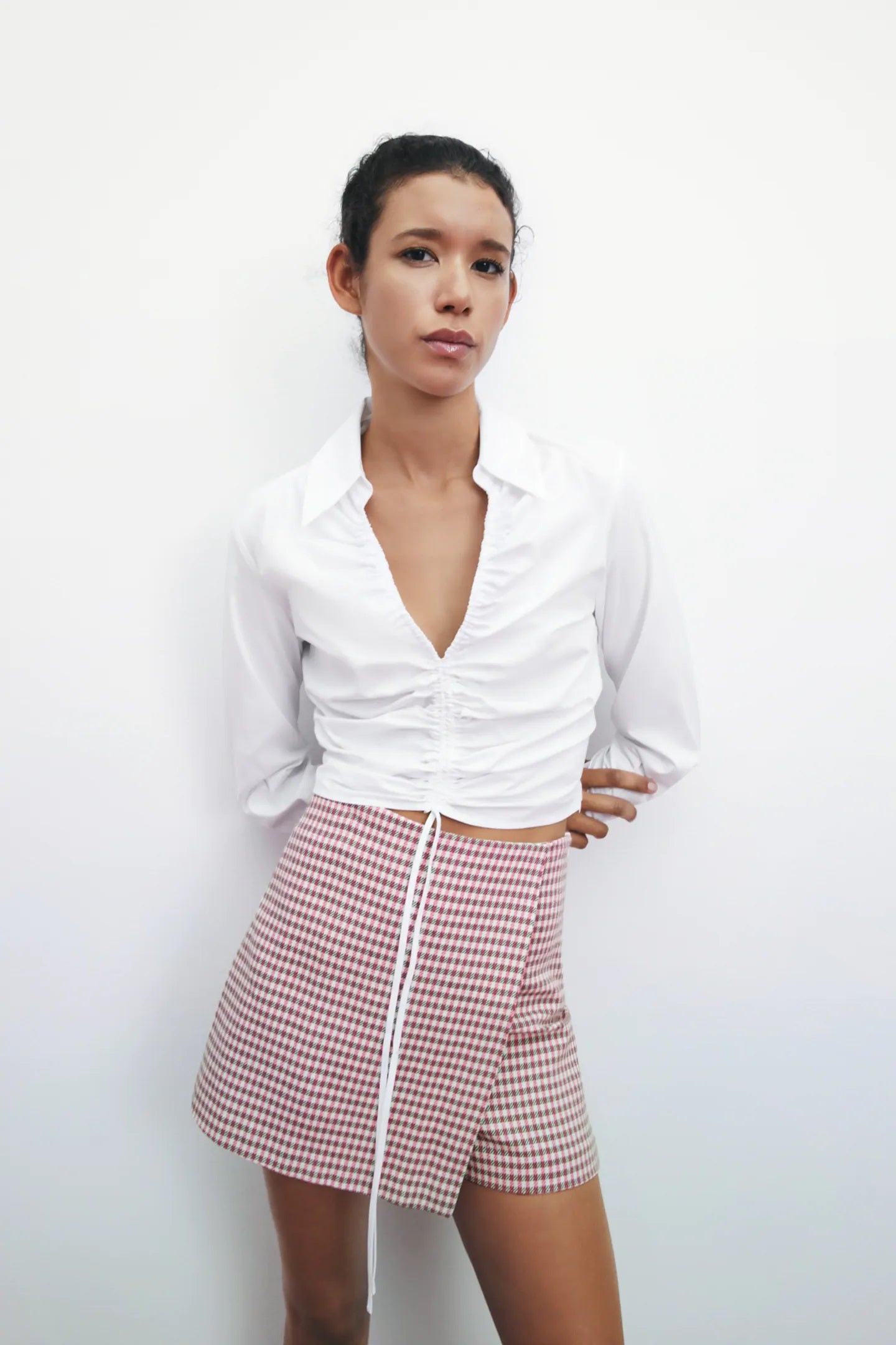 Una camisa blanca para presumir de figura... la fruncida con escote a pico. Un must de primavera y de verano por 22,95 euros en Zara.