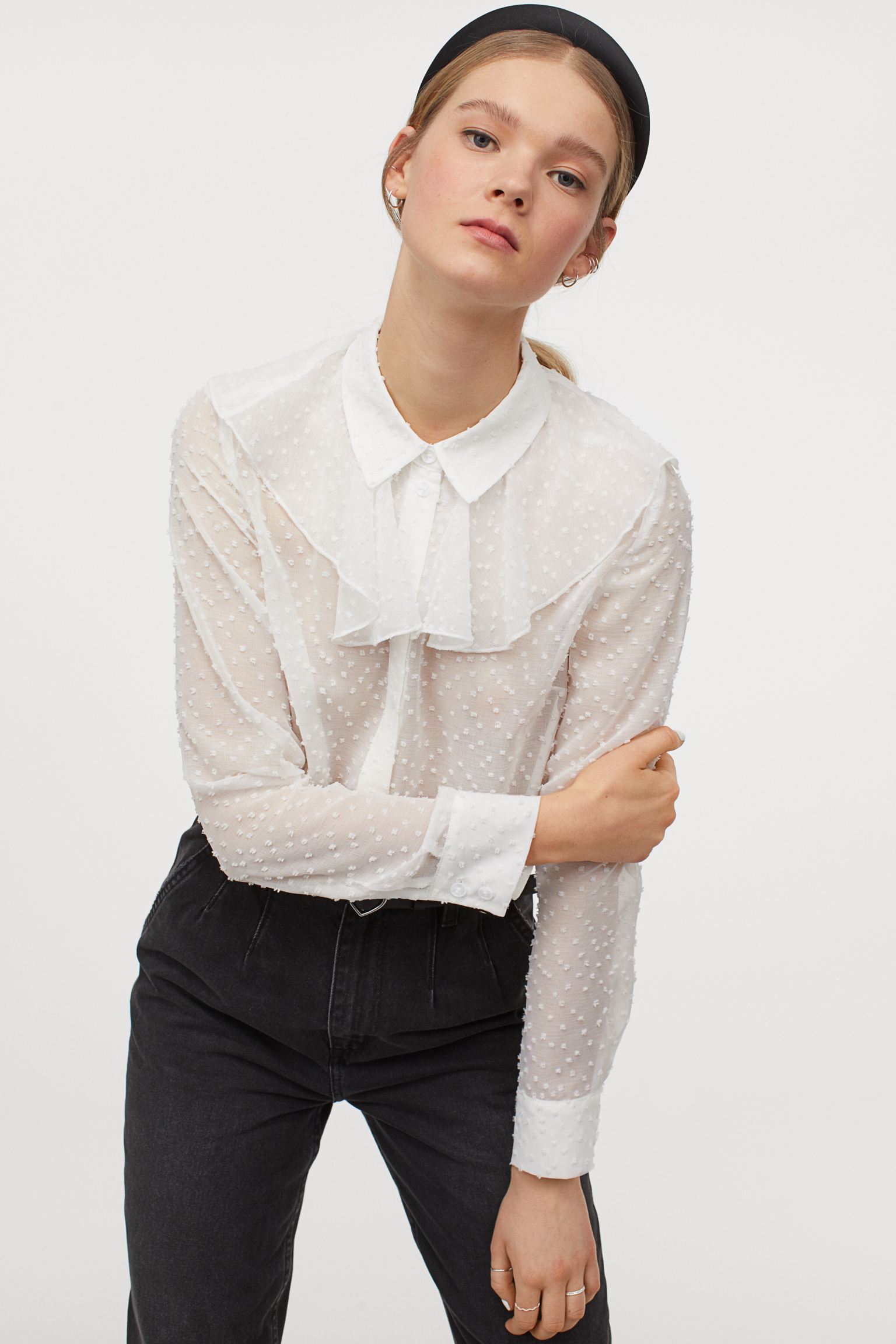 Otra de las camisas blancas que más veremos esta primavera 2021, es este diseño plumeti de gasa de H&M que queda fenomenal con vaqueros. (19,99 euros).