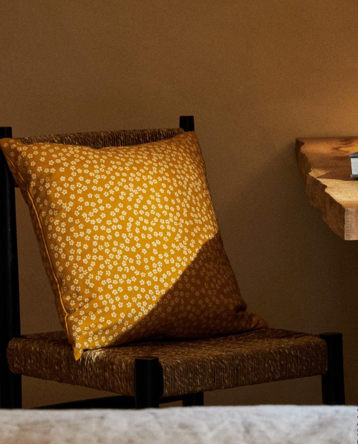 Esta alegre funda de cojín en amarillo mostaza con estampado de flores mini está rebajada en los Special Prices de Zara Home de 9.99 a 7.49 euros.