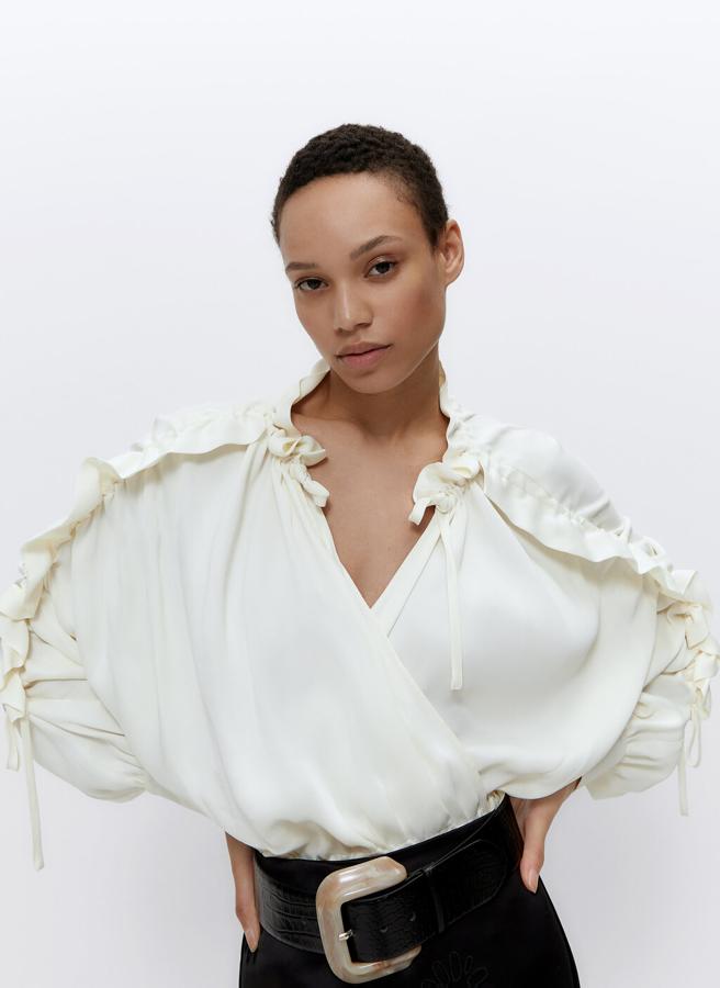 Esta original blusa romántica de silueta cruzada es súper favorecedora y queda igual de bien con vaqueros que con una falda especial o pantalones de talle alto. Cuesta 89 euros en Uterqüe.