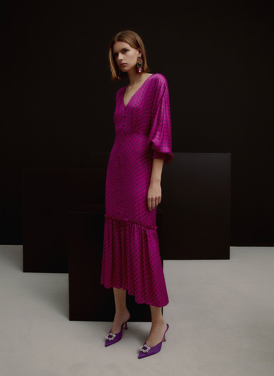 El vestido de lunares es un clásico que se reversiona una temporada tras otra, y sin duda, esta interpretación de Uterqüe, en fucsia y morado, con volantes en el bajo y cuerpo abotonado nos parece de lo más bonito que vamos a ver esta primavera (129 euros).