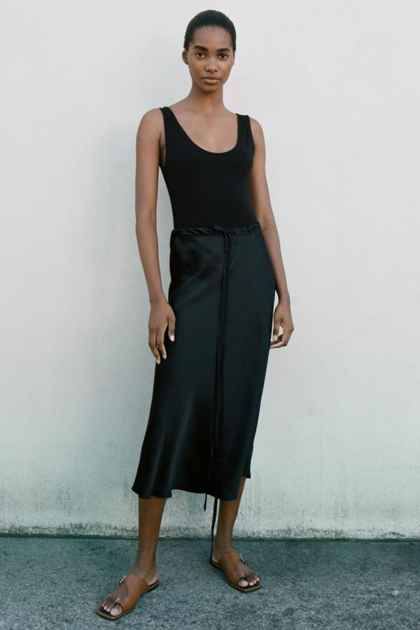 Falda satinada en color negro con cintas de Zara (25,99 euros)