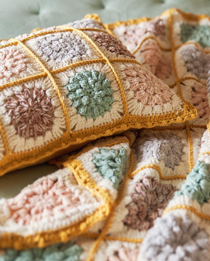 Confeccionado en crochet multicolor con diseño de flores, esta funda de cojín mide 30x40 centímetros y tiene un precio de 17,99 euros.