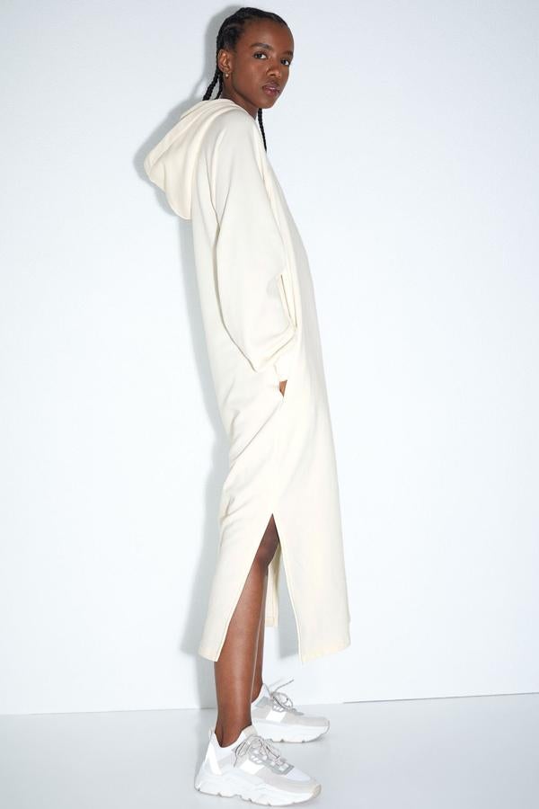 Este vestido midi en tejido de sudadera en color blanco cuenta con capucha de doble capa, manga larga con puños elásticos de canalé y bajo recto con aberturas laterales. Es de H&M y tiene un precio de 24,99 euros.
