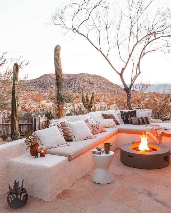 Desde Amazon Home nos inspiran con este espacio 'chill' exterior con un banco de obra y mucho juego de textiles. La mesa con hoguera es perfecta para alargar las veladas hasta el infinito.