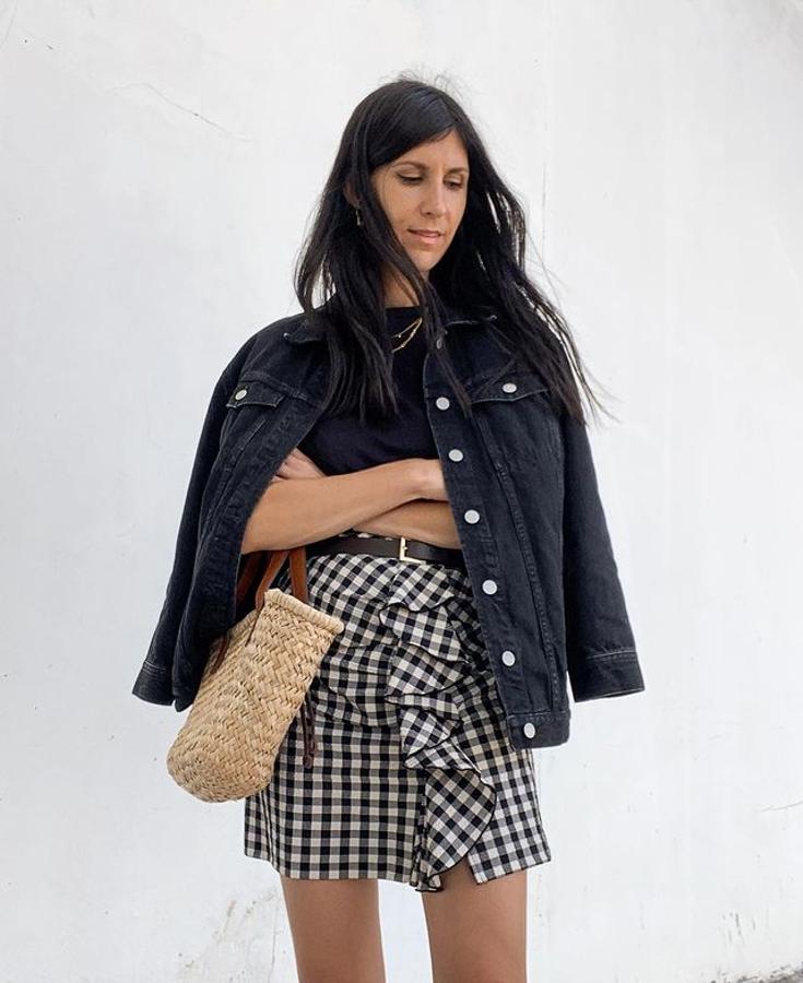 Un look perfecto para los días de entretiempo: cazadora vaquera, minifalda estampada y bolso de rafia.