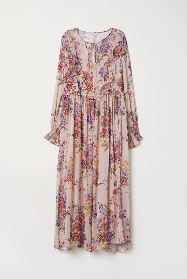 Vestido largo en tejido vaporoso con estampado y volantes de la nueva colección de H&M (59,99 euros). Lleva escote redondo con abertura en V y tiras de anudar, volantes delante, mangas largas abullonadas con fruncido y volante en los puños, y costura de volantes en la cintura. Va parcialmente forrado.