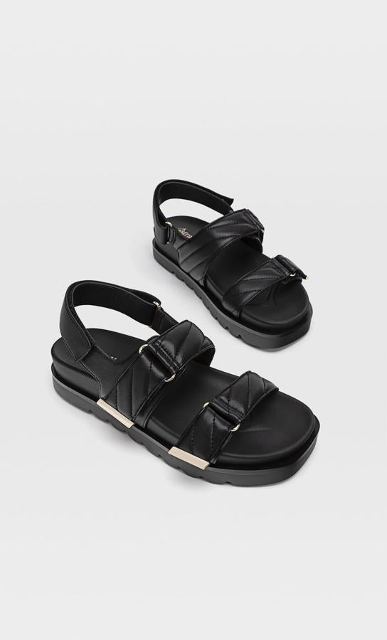 En color negro y con tiras acolchadas, esta sandalia con detalles plateados tienen un precio de 25,99 euros.