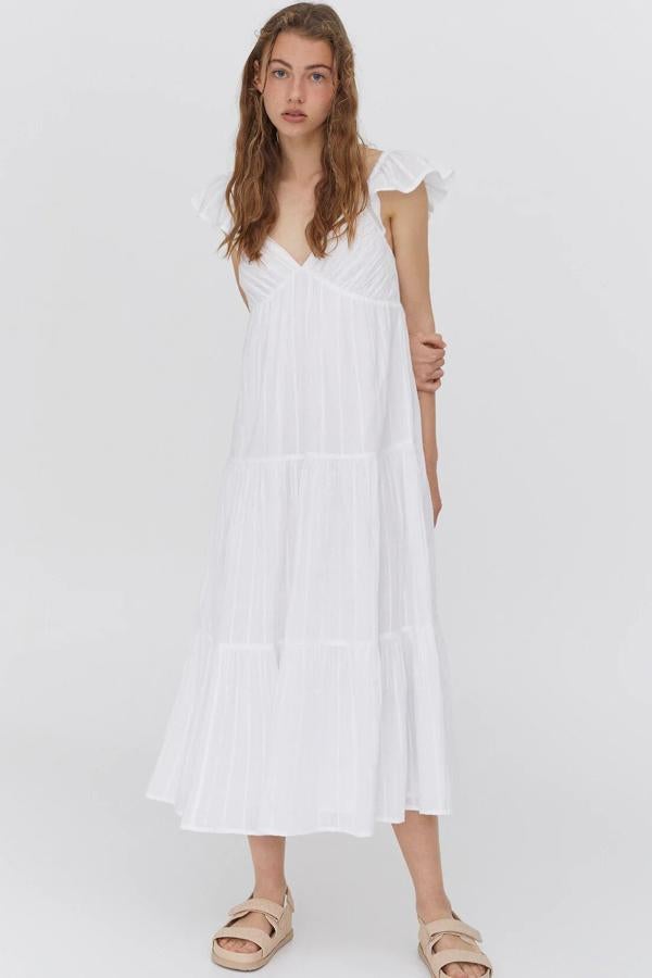 Confeccionado en 100% algodón de color blanco, este vestido midi de tirantes con volantes y escote de pico cuenta con cazuelas y detalles de cortes horizontales. Es de Pull & Bear y tiene un precio de 29,99 euros.