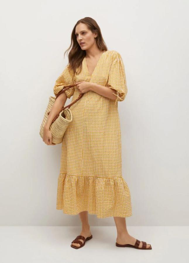 Vestido de algodón en color amarillo de Mango (exclusivo online). Diseño midi y acampanado. Escote en pico, manga abullonada y volante en el bajo. Precio: 49,99 euros.
