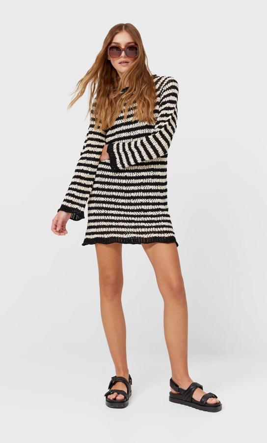 Vestido de crochet y rayas de Stradivarius. Precio: 29,99 euros. Es corto, tiene el cuello en pico y manga larga y está tejido con una de las tendencias indiscutibles de temporada.