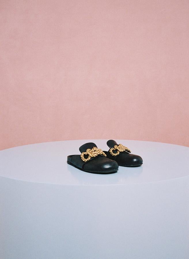 Mules planas de piel con adornos metálicos en el empeine, de Uterqüe (119 €).