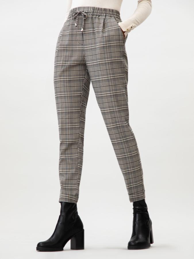 Con estampado de cuadros en tonos beige, este pantalón de corte jogger cuenta con goma en la cintura y cordón. Cuenta con bolsillos y tiene un precio de 15,99 euros.