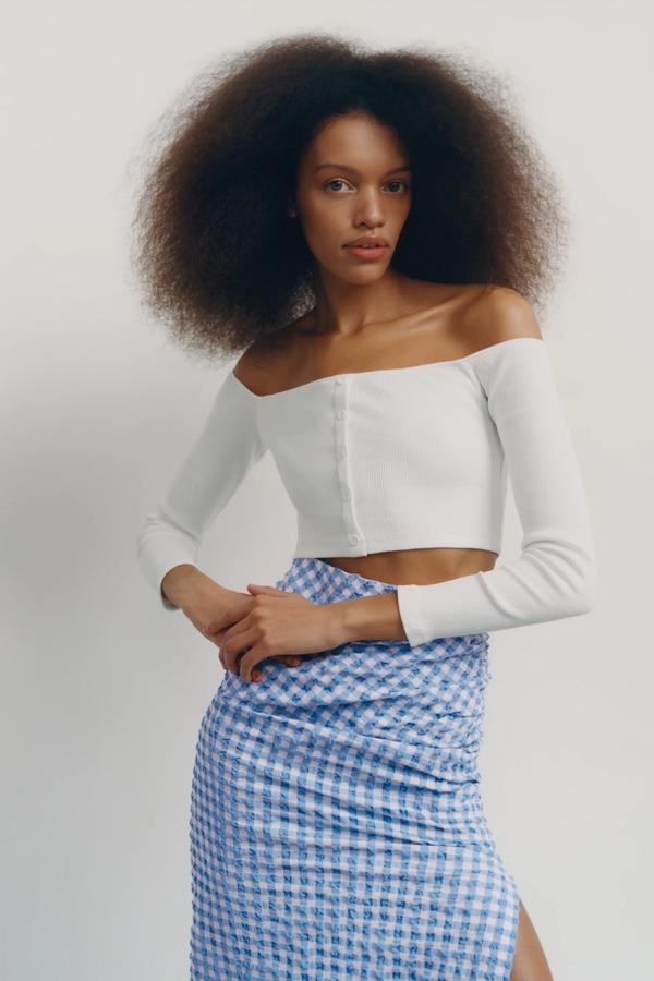 Disponible en blanco, negro o con estampado de rayas, esta camiseta corta con escote recto y manga larga cuenta con detalle de botones en la parte delantera y tiene un precio de 5,99 euros (antes 12,95 euros).