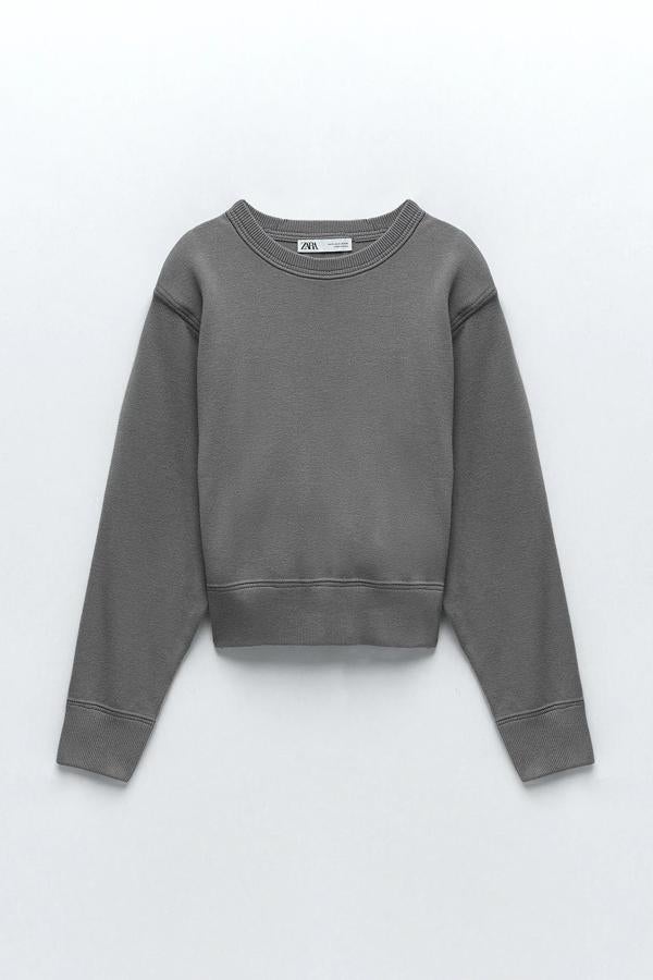 En color gris medio, esta sudadera de punto oversize con cuello redondo y manga acabada en puño tiene un precio de 15,99 euros (antes 25,95 euros).