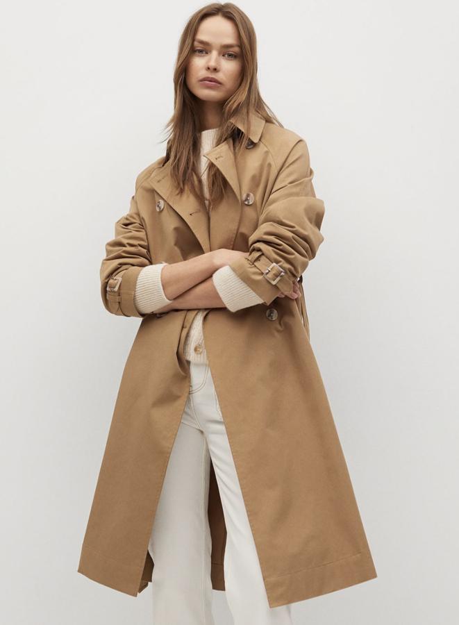 Disponible en beige o en color piedra, este trench en tejido técnico repelente al agua cuenta con diseño cruzado y cuello de solapa. Con cinturón desmontable, tiene un precio de 49,99 euros (antes 79,99 euros).