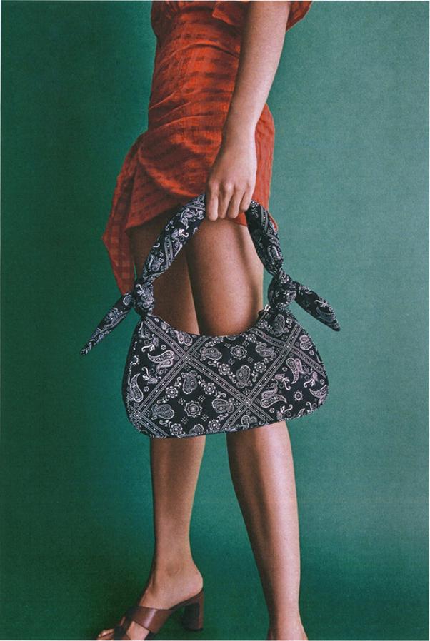 Con detalle de nudos en ambos lados del asa de hombro y cuerpo con estampado paisley, este bolso negro y blanco de Zara de hombro con cierre de cremallera superior cuesta 19,95 euros.