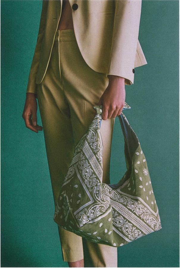 Disponible en verde o en naranja, este bolso formato saca con cuerpo estampado tipo bandana es de Zara y viene con saca de hombro con detalle de nudo e interior forrado. Cuesta 19,95 euros.