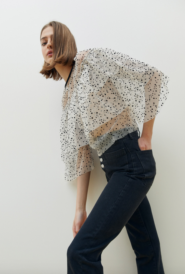 Estamos seguras de que no va a aparecer ninguna camiseta como esta en el low cost. Confeccionada con un flocado de lunares y cuello a la caja, tiene una ligereza maravillosa (25,99 euros).