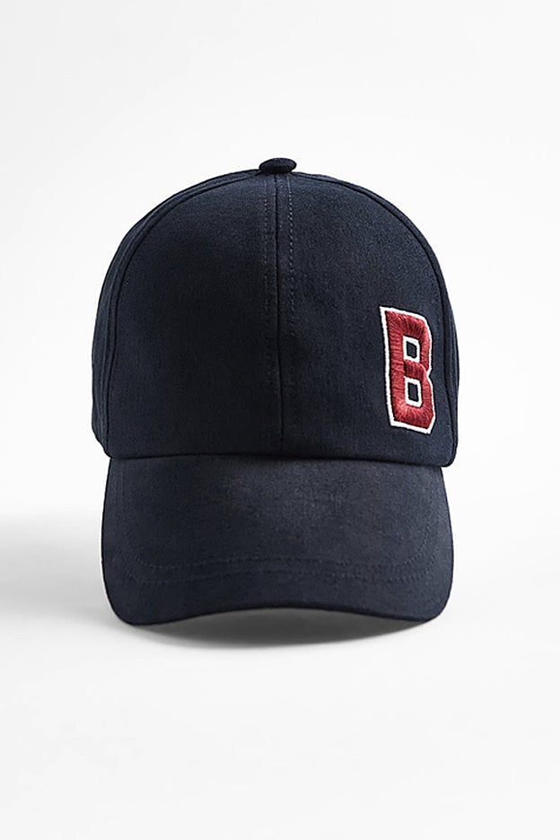 Gorra de visera azul marino con una inicial bordada de Zara.