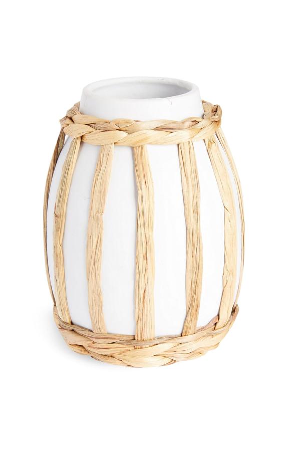 Este jarrón de cerámica en color blanco y detalles de ratán en tono natural tiene un precio de 6 euros.