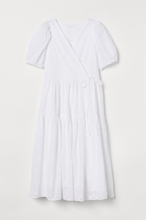 Con bordado inglés, este vestido midi de color blanco cuenta con cuerpo cruzado y mangas cortas abullonadas. Con lazada en un lateral, es de H&M y tiene un precio de 49,99 euros.