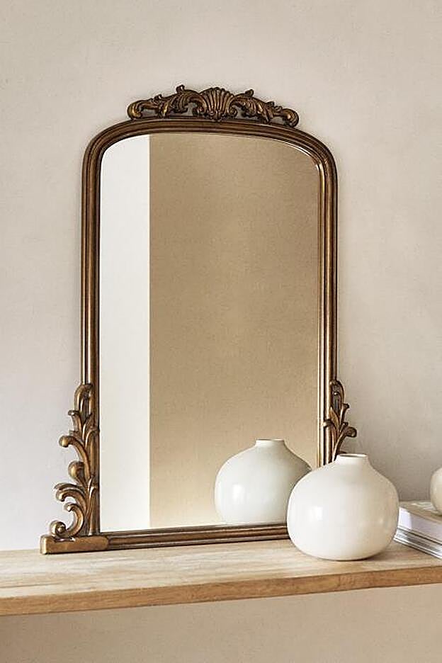 Espejo dorado con volutas de Zara Home.