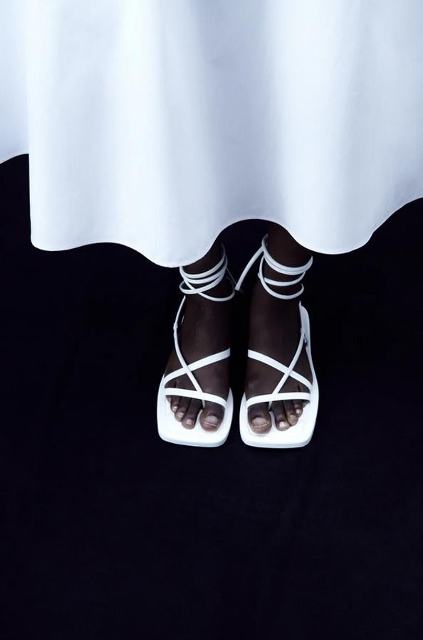 Estas sandalias planas blancas de Zara con tiras de piel con posición para el dedo y cierre de atado en el tobillo vienen con punta cuadrada y están disponibles entre los números 36 y 41 por 59,95 euros.