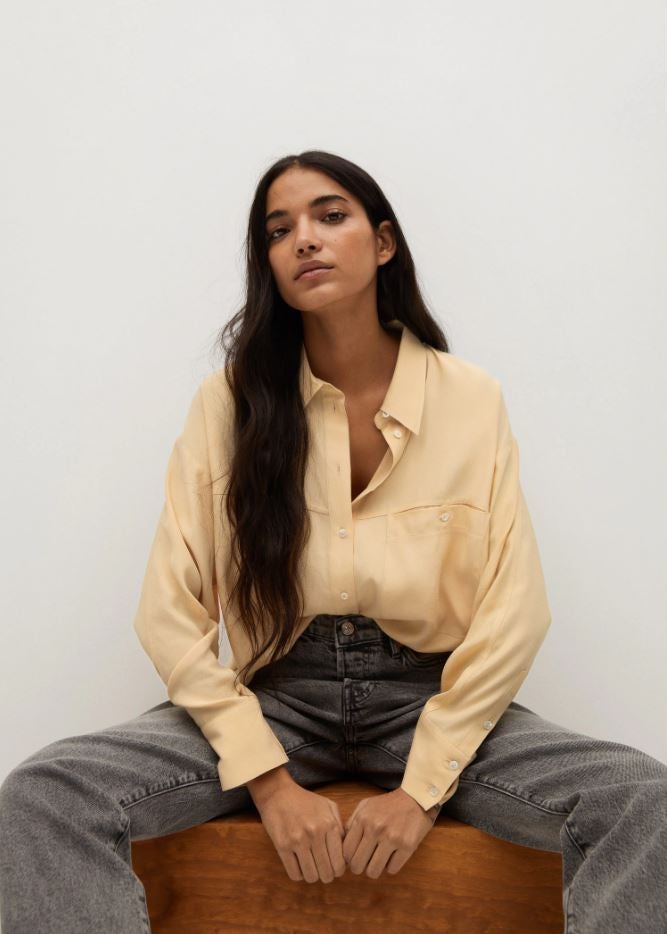 Blusa fluida en tono vainilla (disponible en dos colores más), rebajada a 19.99 euros en Mango.