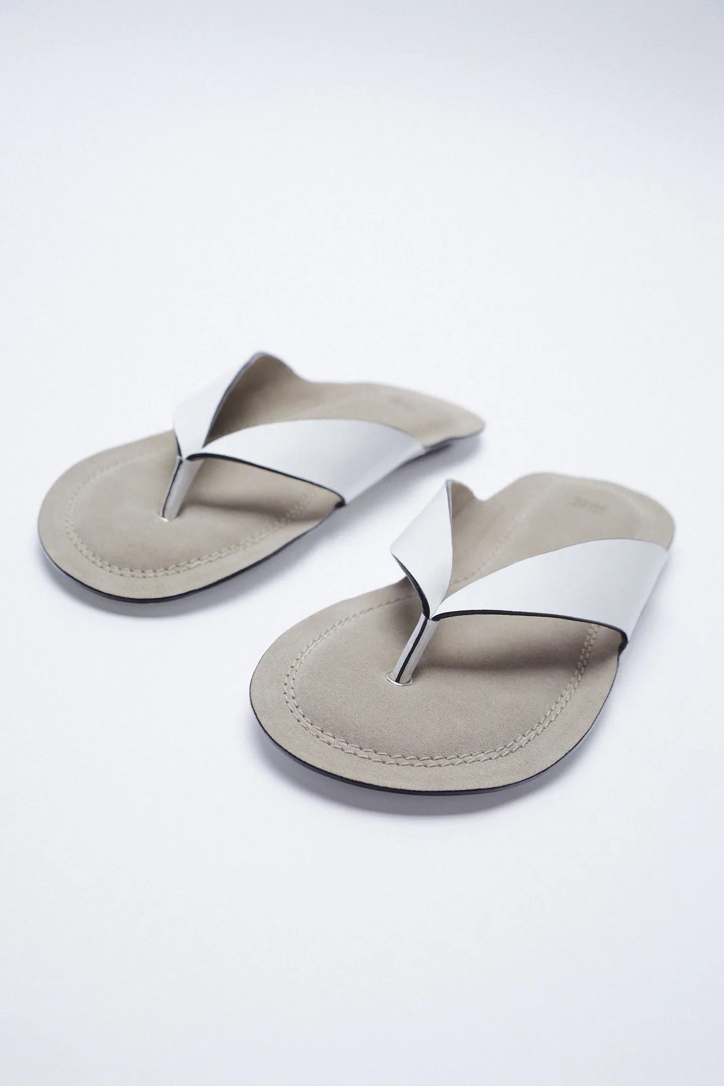 Sandalias blancas planas y flexibles de piel. (45,95 euros).