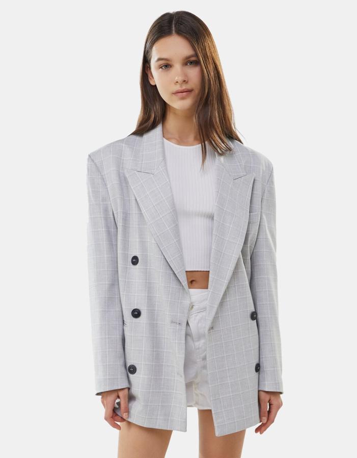 En color gris con estampado de cuadros y cierre frontal de tres botones a contraste, esta blazer confeccionada con al menos un 25% de poliéster reciclado tiene bolsillos al bies y de 39,99 euros ha pasado a costar 23,99 euros. Está disponible entre las tallas XS y L.
