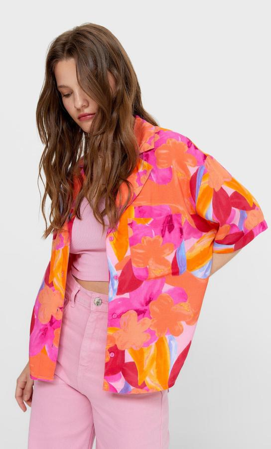 En tonos naranjas, rojos y fucsias, esta camisa con estampado de flores maxi viene con cuello de solapa con muesca, escote de pico y bolsillo de plastrón en la pechera. Tiene cierre frontal de botones a tono, cuesta 15,99 euros y está disponible entre las tallas S y L.