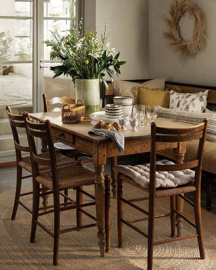 El estilo rústico es el protagonista de esta mesa en la que la vajilla de cerámica está disponible a partir de 7,99 euros, los cojines de la silla cuestan 12.99 euros, y la alfombra de yute, 129 euros.