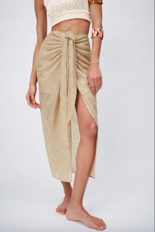 De tiro alto, con detalle de nudo con pliegues en delantero y bajo con abertura frontal, esta falda midi en color oro viene con cierre en espalda con cremallera oculta en costura. Tiene un precio de 39,95 euros y solo queda en la talla L.